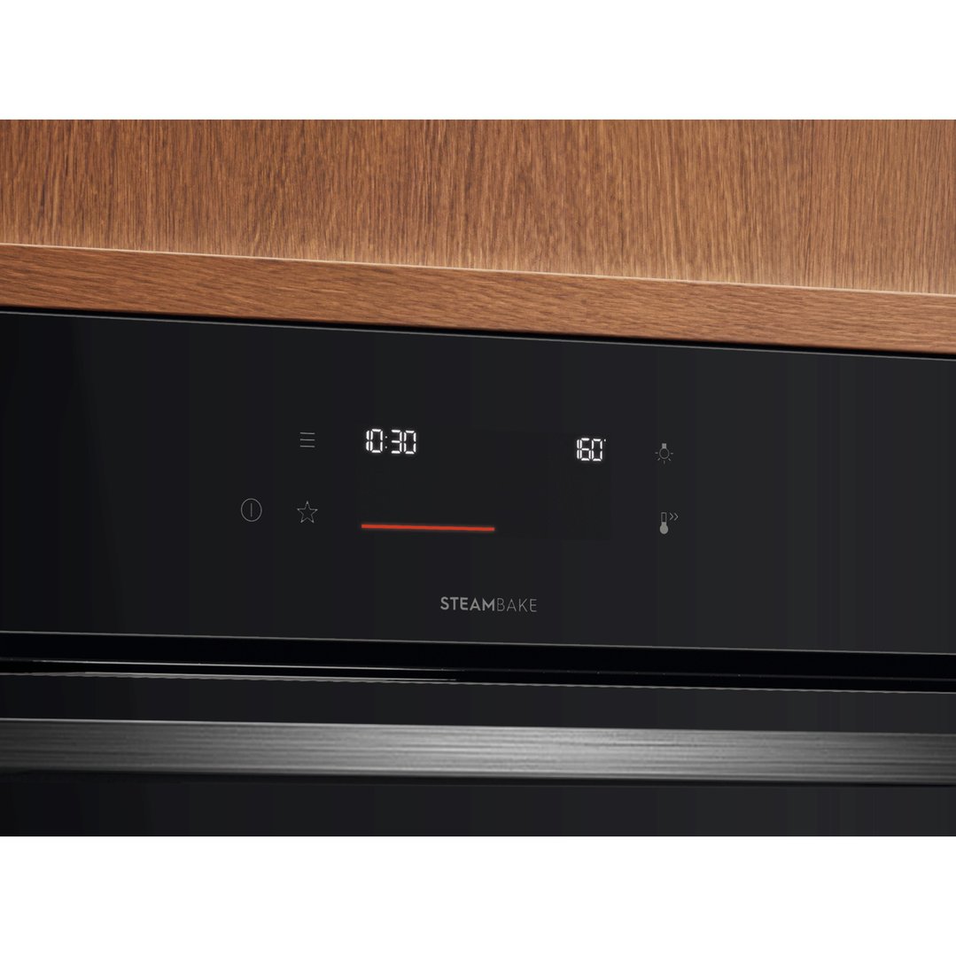 Close up of a built-in oven control panel with a wooden cabinet above
