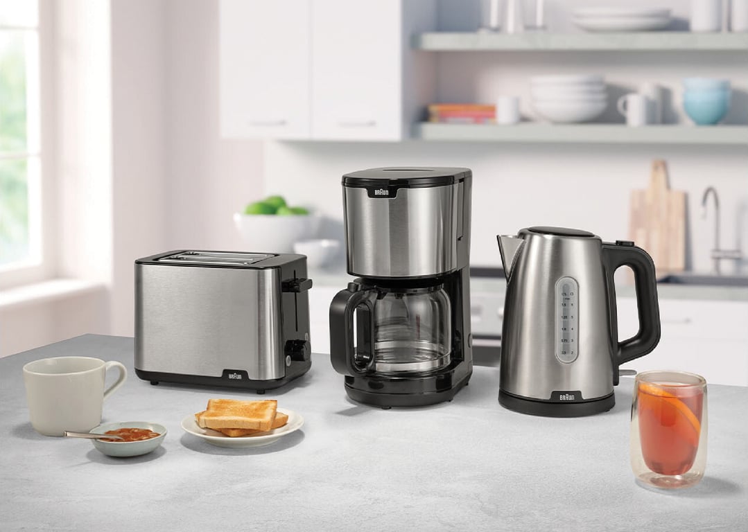 Braun toaster, coffee maker, and kettle on a kitchen counter with breakfast items