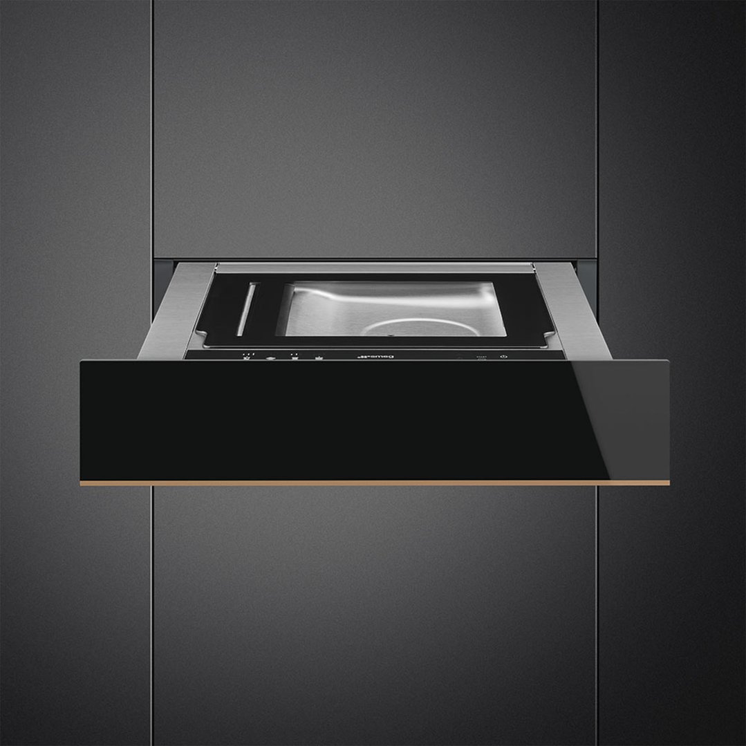 A warming drawer partially open, built into dark cabinetry