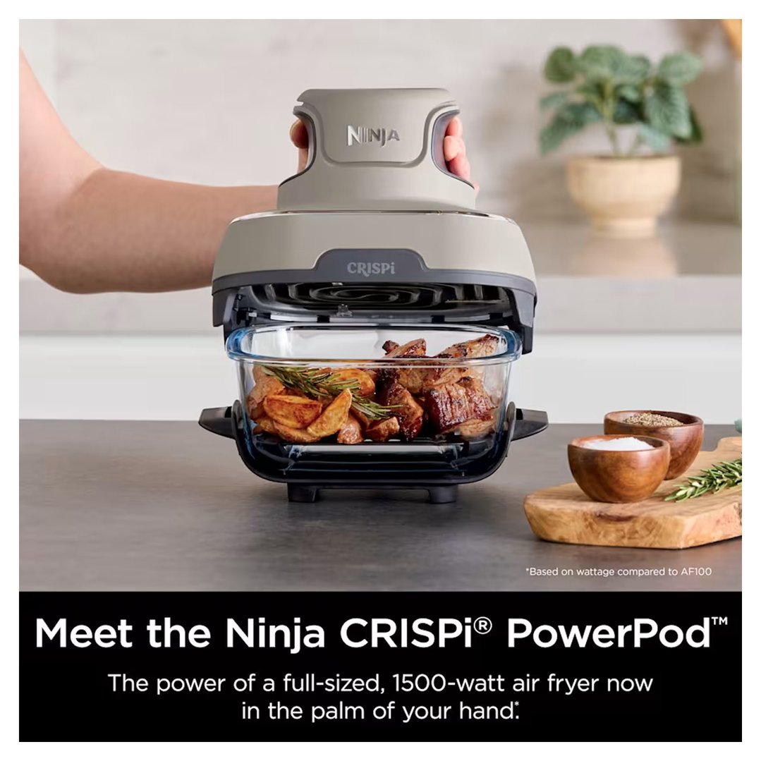 Hand holding the top of a Ninja Crispi air fryer with food inside