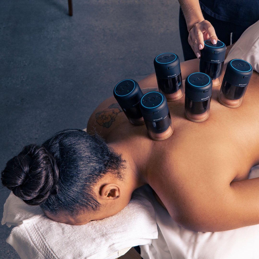TheraCup massagers on a person's back during a cupping session