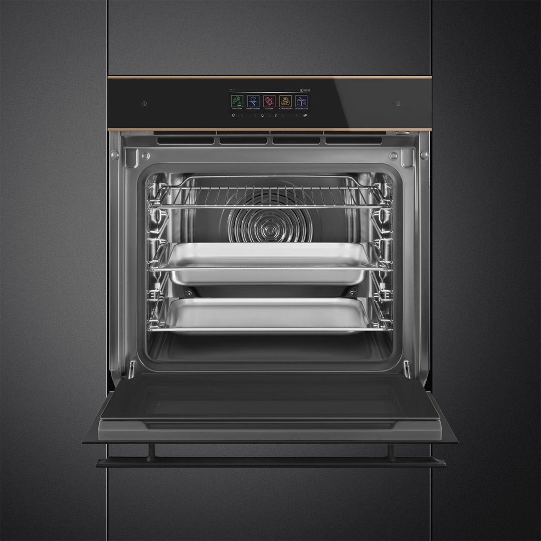 Built-in black glass oven with copper trim, door open, showing interior with trays