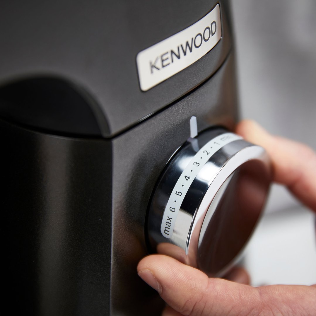 Hand adjusting the speed dial on a Kenwood food mixer
