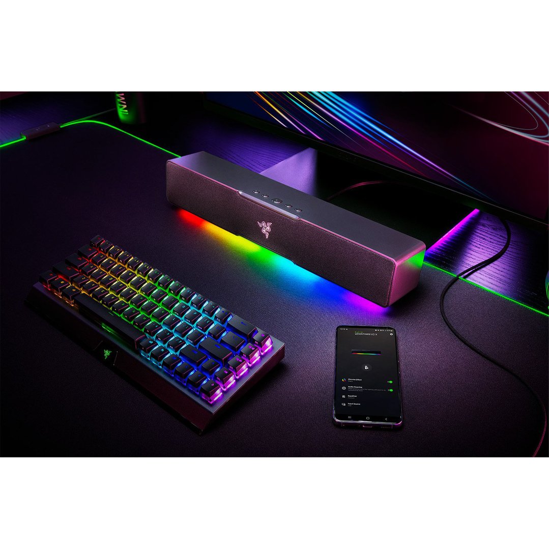 Razer Leviathan V2 X Gaming Soundbar and keyboard on a desk with RGB lighting