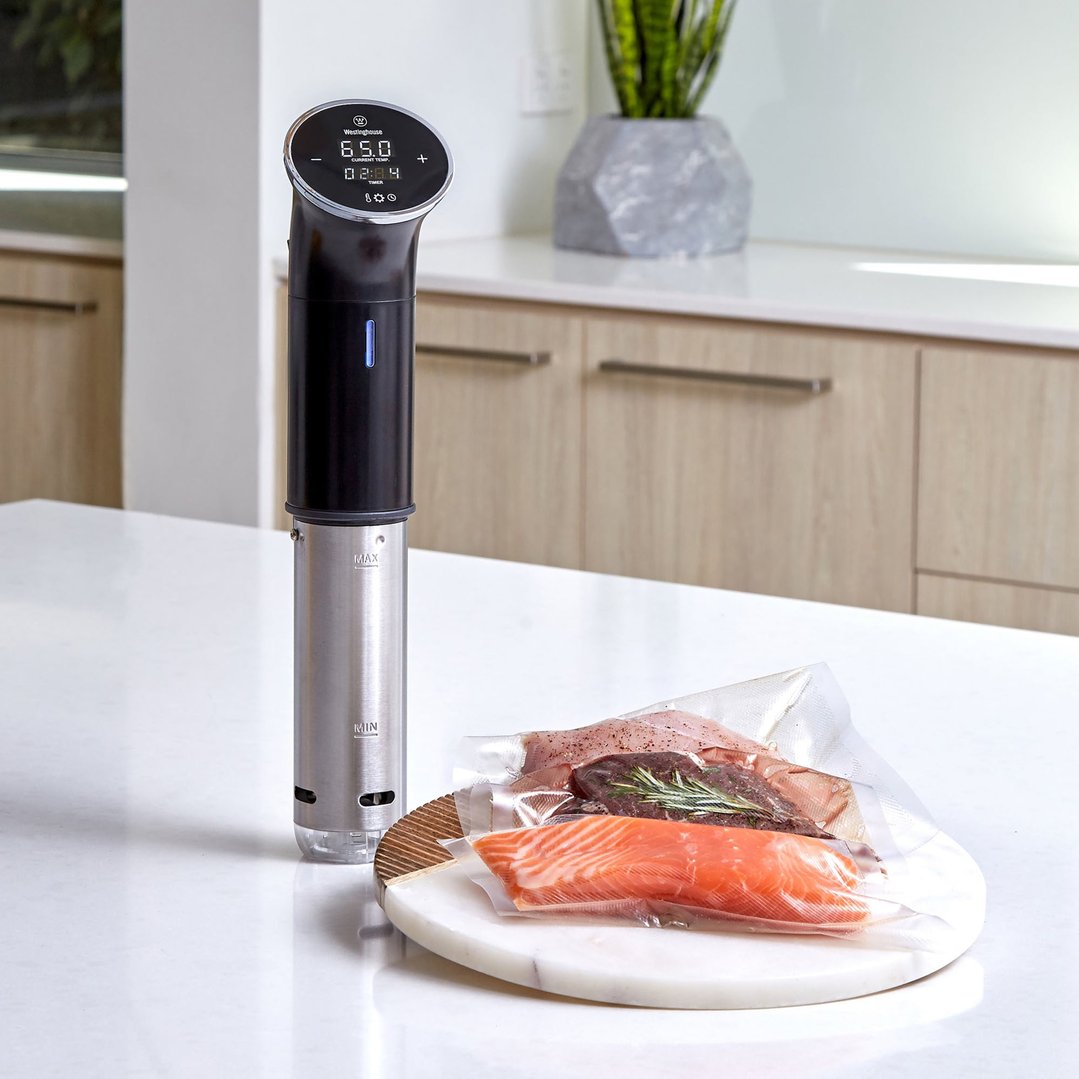 Sous Vide Immersion Cooker on a kitchen counter with vacuum-sealed food