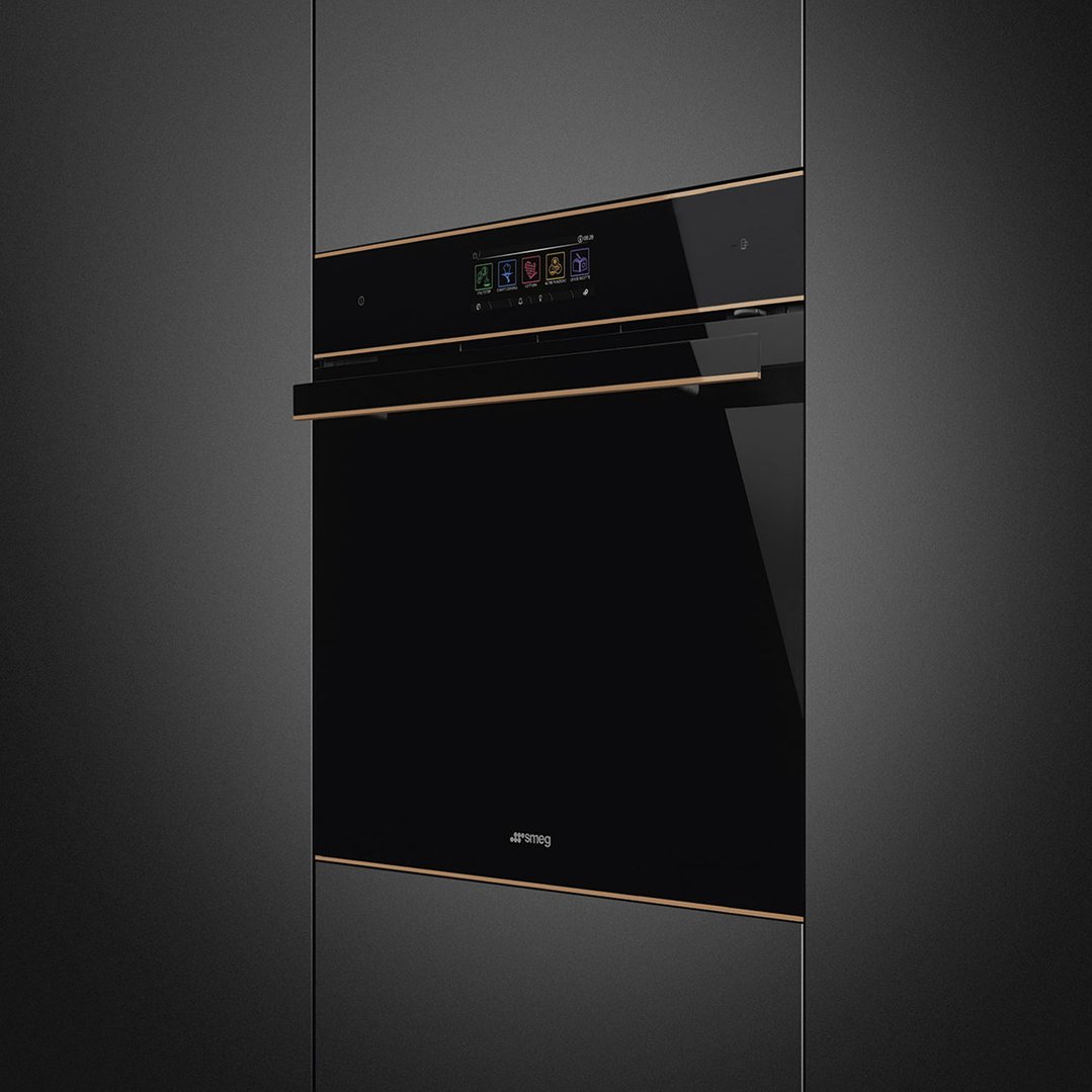 Black glass oven with copper trim built into dark cabinetry