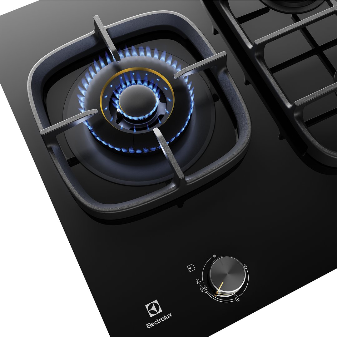 Close up of a black gas cooktop with a lit burner and control knob