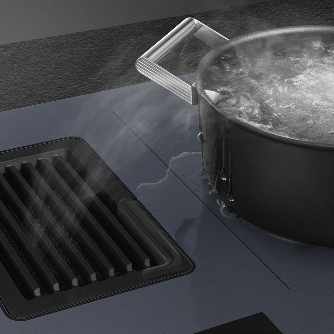 Boiling pot on an integrated induction cooktop with AutoVent 2.0 in a kitchen