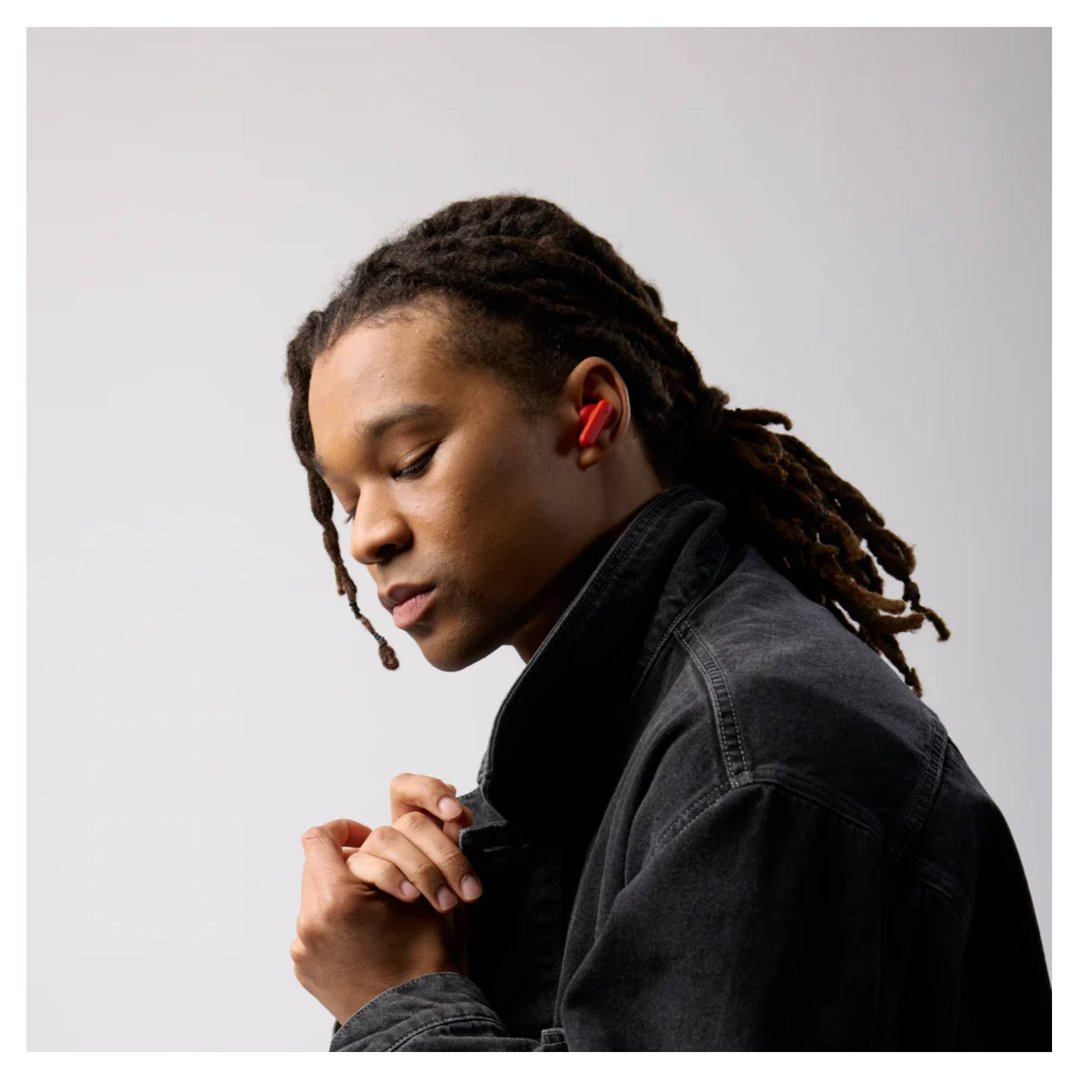 Man with dreadlocks wearing red Skullcandy Smokin Buds TWS in-ear headphones