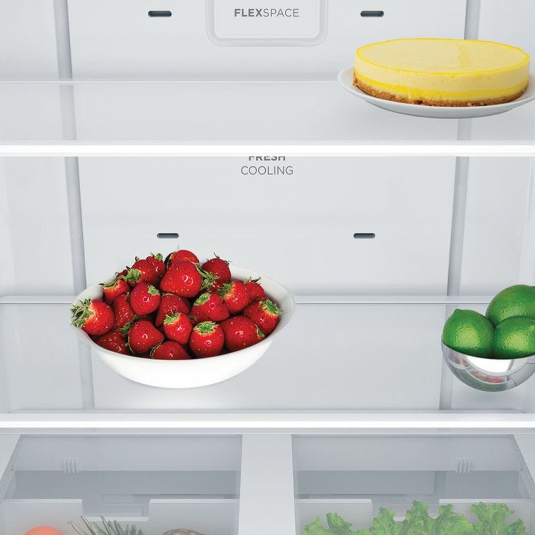 Inside a Westinghouse fridge with cheesecake, strawberries, and limes on shelves