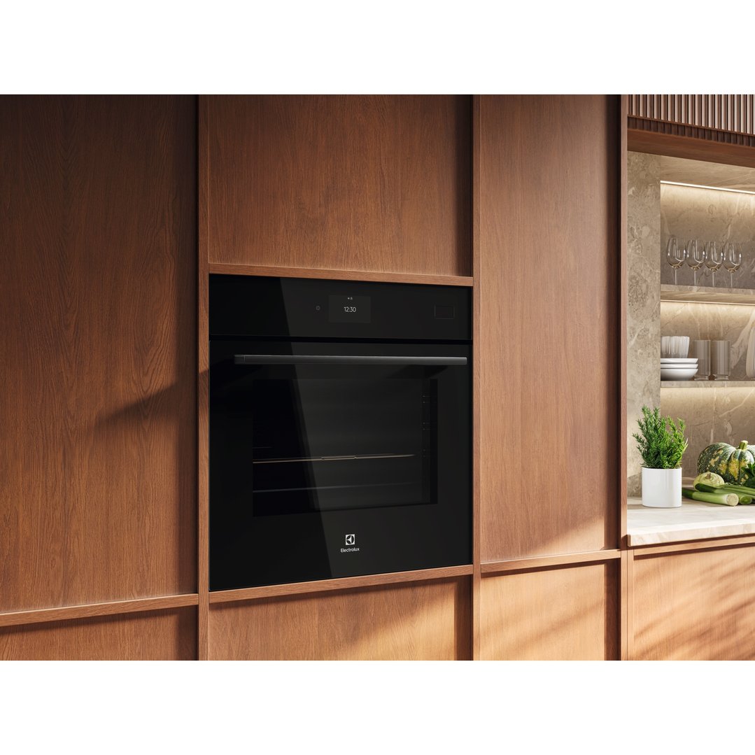 Black built-in oven with digital display in a modern kitchen with wooden cabinetry