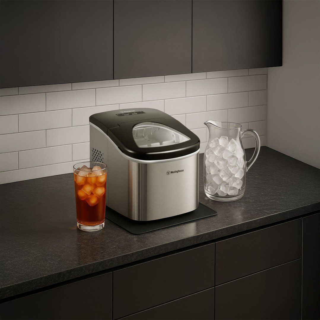 Ice Maker on a dark countertop with a glass of iced tea and a pitcher of ice