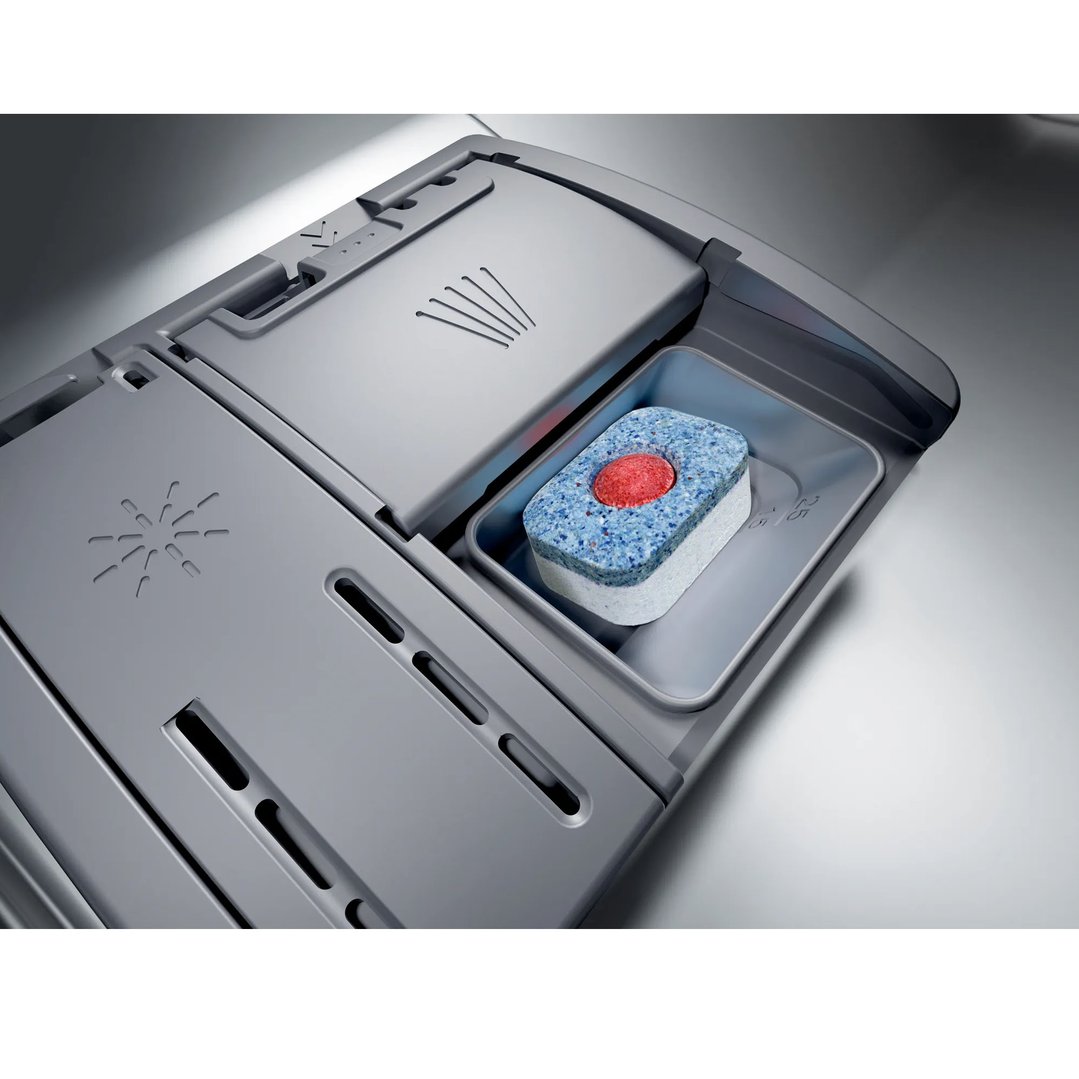 Close-up of a dishwasher's detergent dispenser with a tablet inside