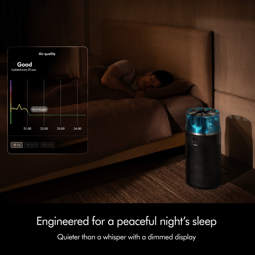 Dyson air purifier next to a bed with a person sleeping, showing air quality app