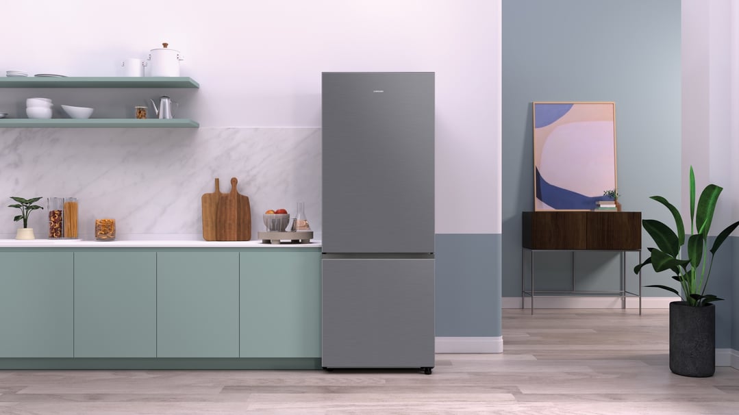 Silver bottom mount refrigerator in a modern kitchen with light green cabinets