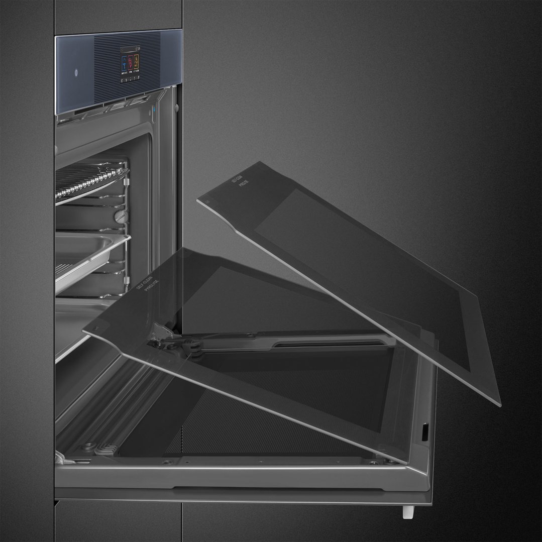A close-up of a dark grey oven with its door open and glass panels removed