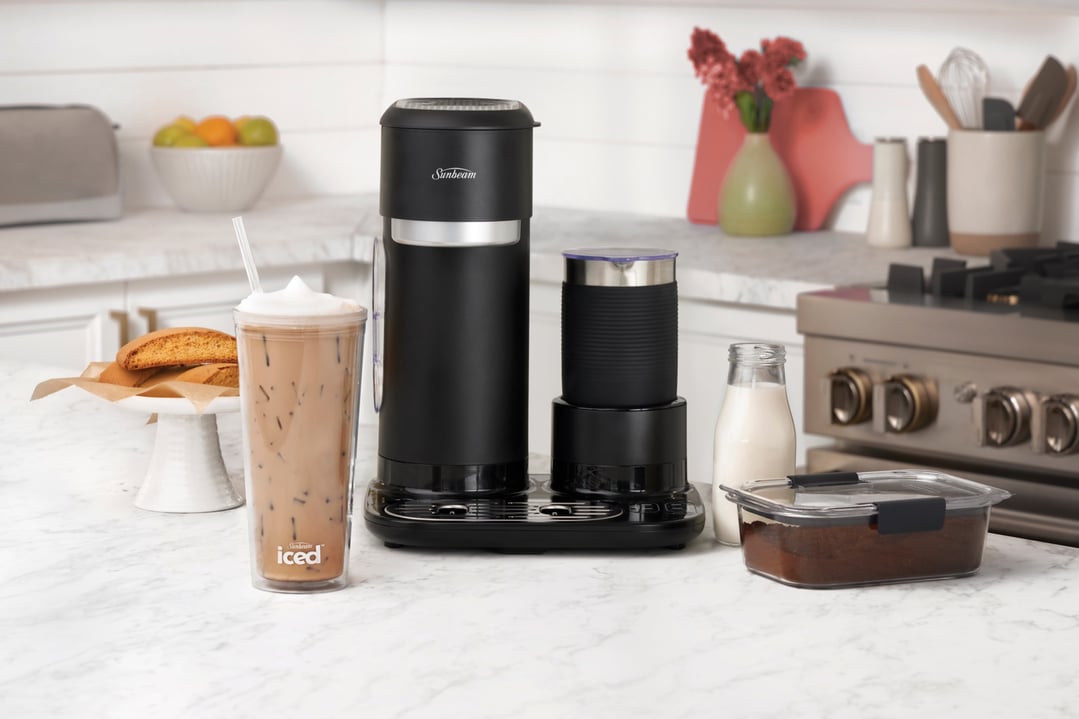 Black coffee machine and frother on a kitchen counter with iced coffee