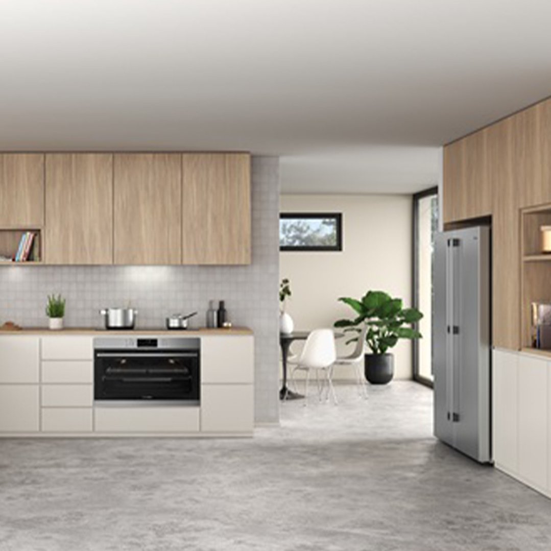 Stainless steel vertical freezer in a modern kitchen with light wood cabinets