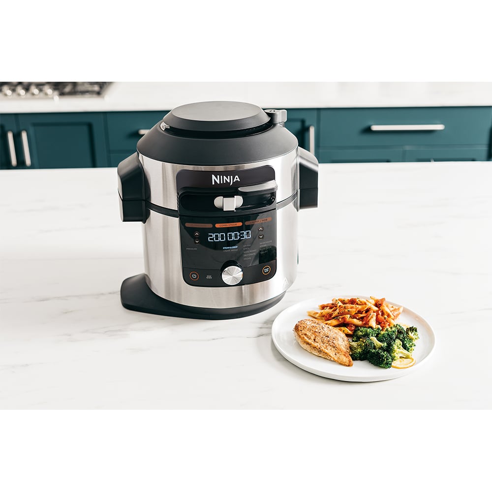 Ninja multicooker on a kitchen counter with a plate of food