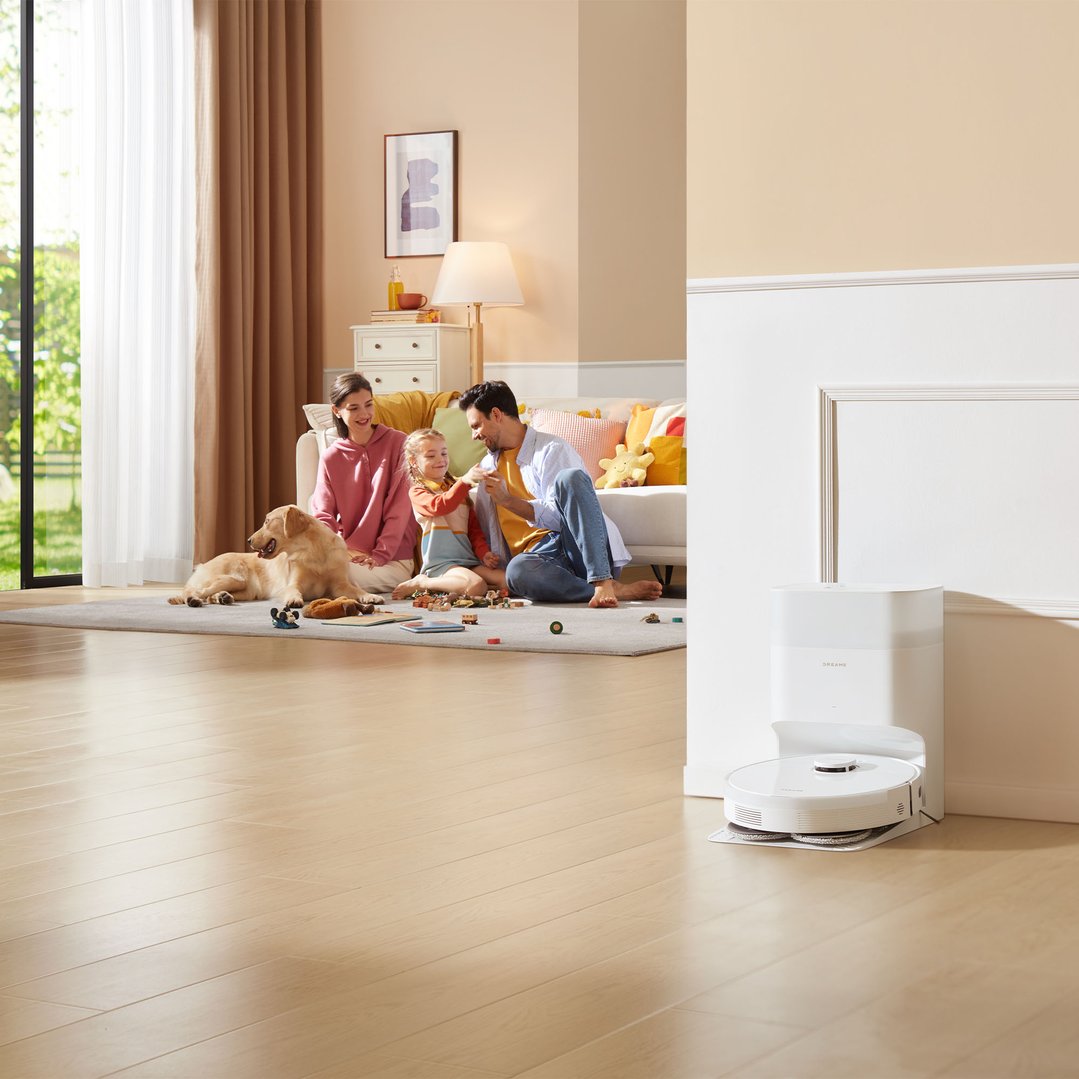 A DREAME robot vacuum cleaner and dock in a living room with a family