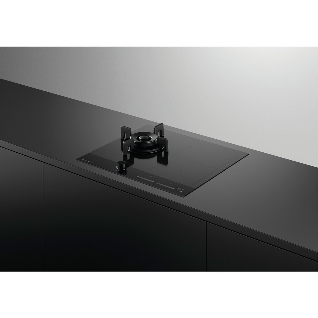 Black hybrid cooktop with gas burner and induction zones on a dark countertop