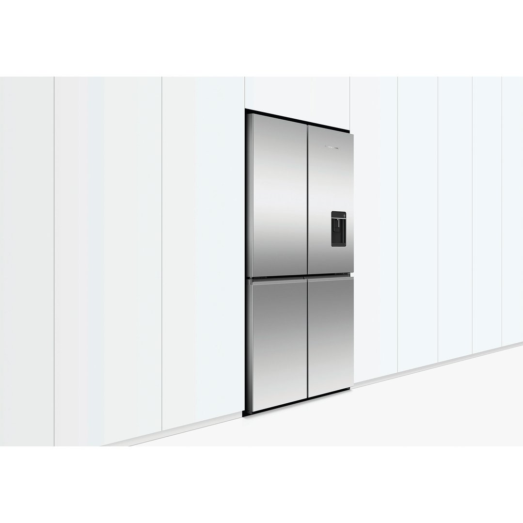 Stainless steel quad door refrigerator freezer with ice and water dispenser built into white cabinetry