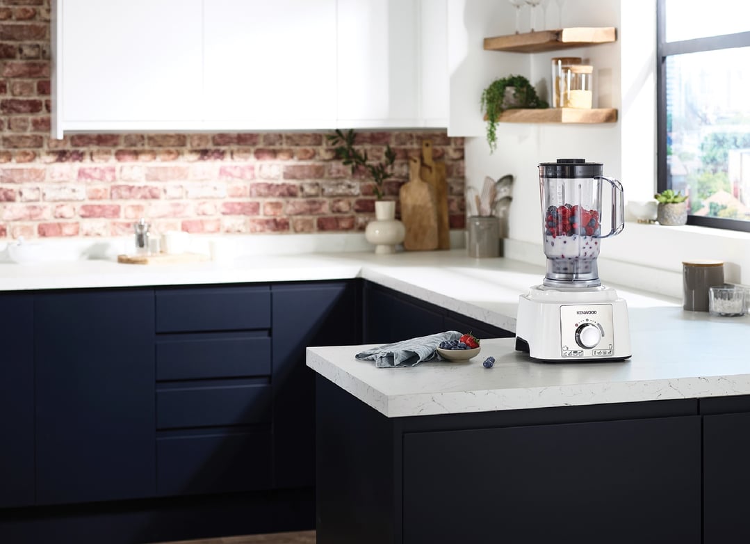 White Kenwood food processor with berries and milk on a kitchen counter