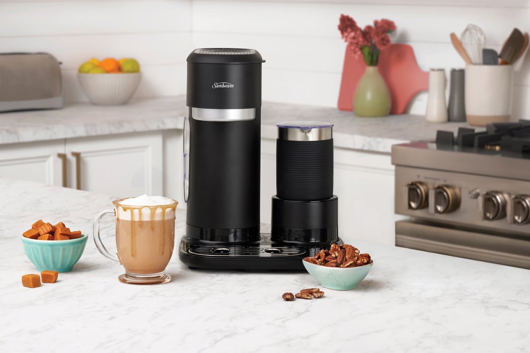 Sunbeam coffee machine and milk frother on a kitchen counter with a caramel latte