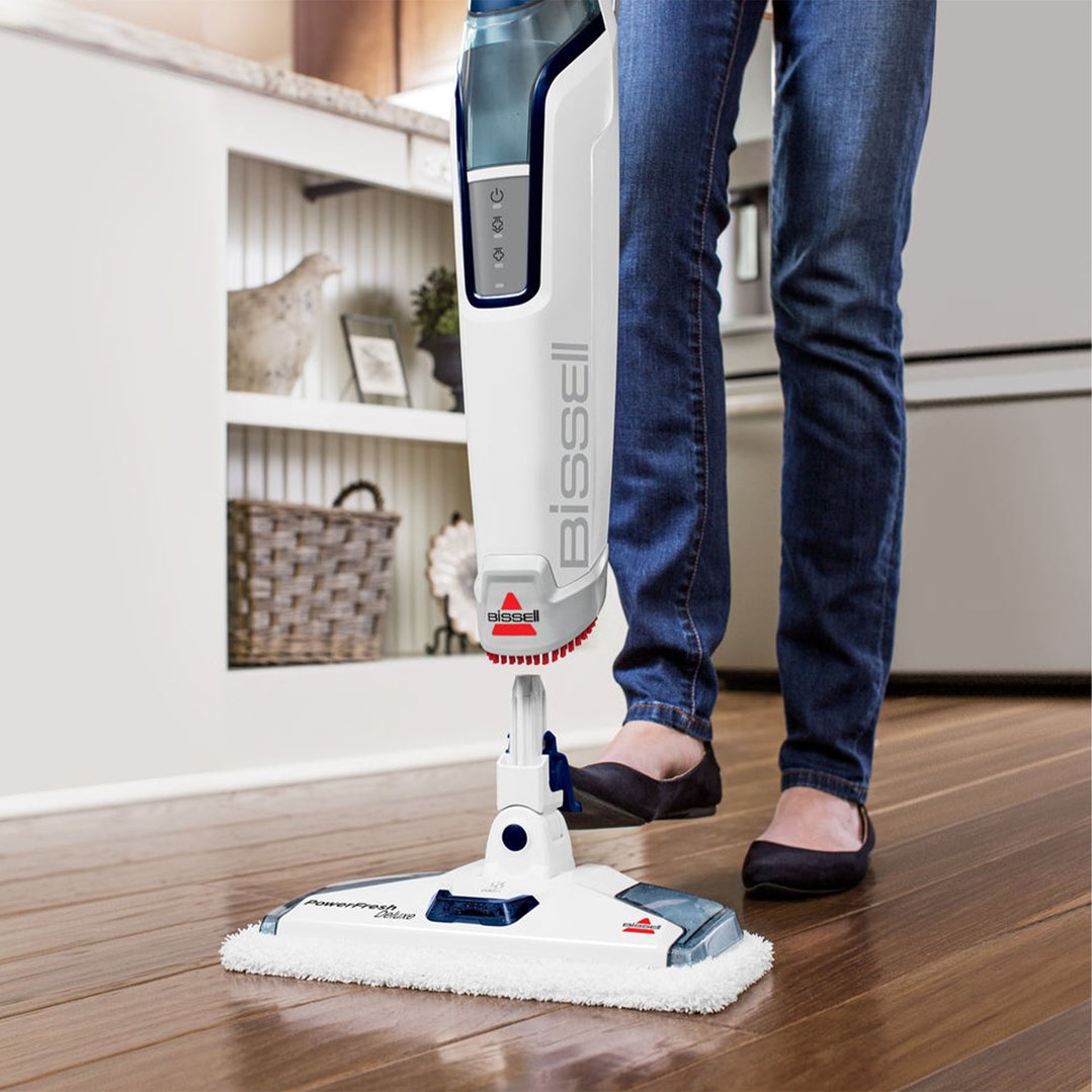 Person using a Bissell PowerFresh Deluxe steam mop on a wooden floor