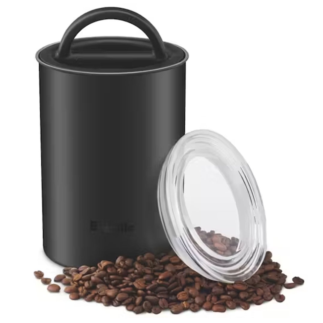 Black Breville coffee canister with lid and coffee beans on a white surface