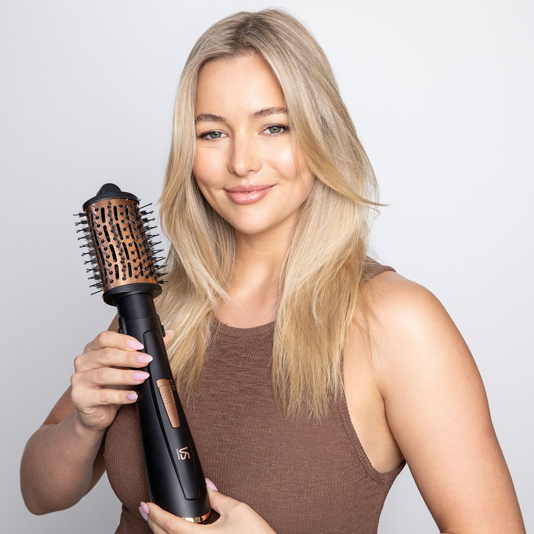 Woman holding a VS SASSOON Air Style Brilliance 7-in-1 hair styler