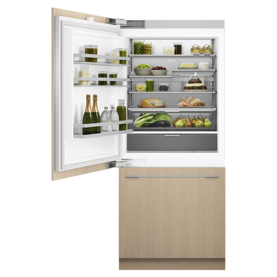 Integrated refrigerator freezer with left-hinged door open, filled with food items