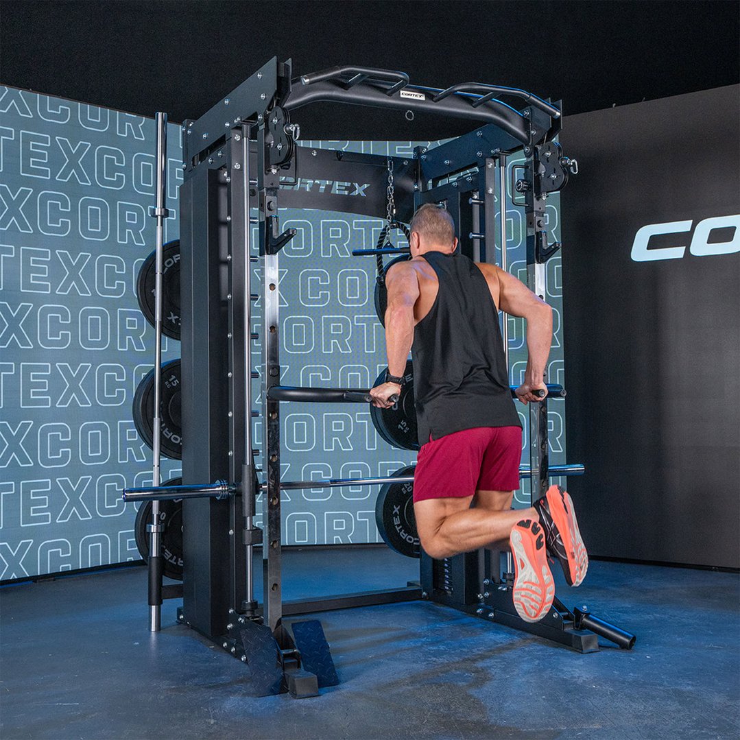 Man performing dips on a power rack with dual stack smith and cable machine