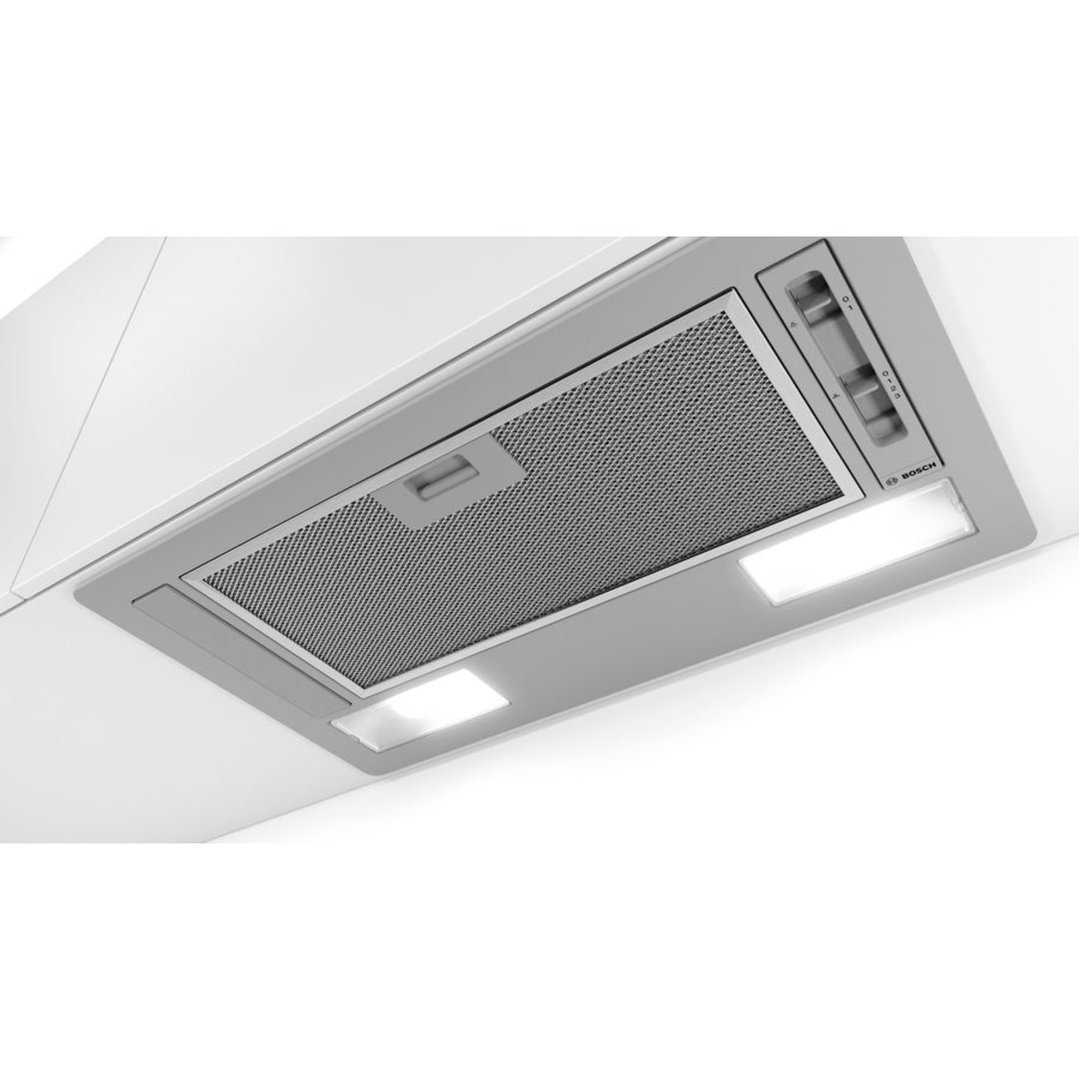 Integrated rangehood with lights and controls, installed in a white kitchen cabinet