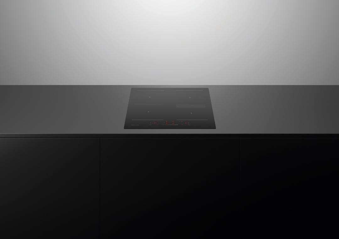 Black induction cooktop with red display on a dark grey countertop