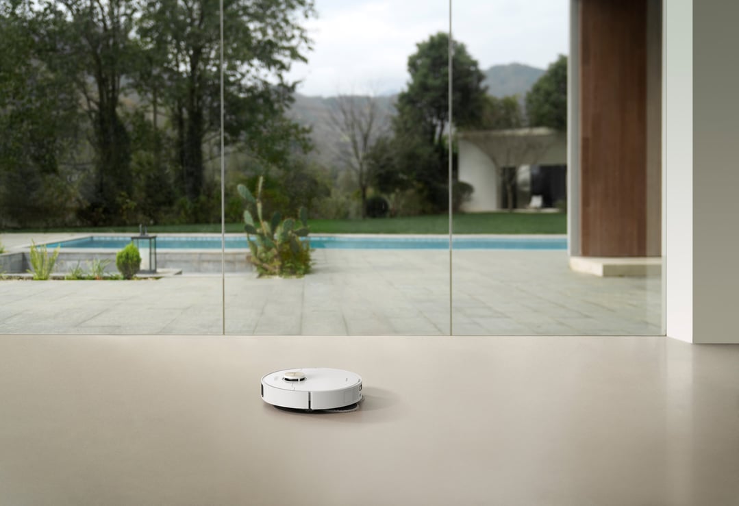 White robot vacuum and mop on a light floor in a modern home