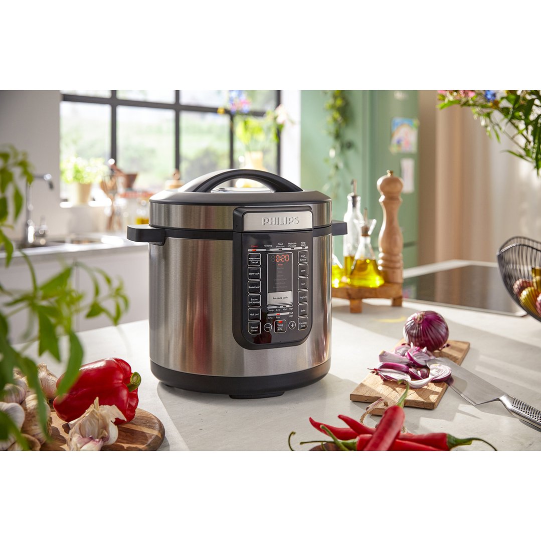 Philips All-in-One Cooker on a kitchen counter with vegetables and spices