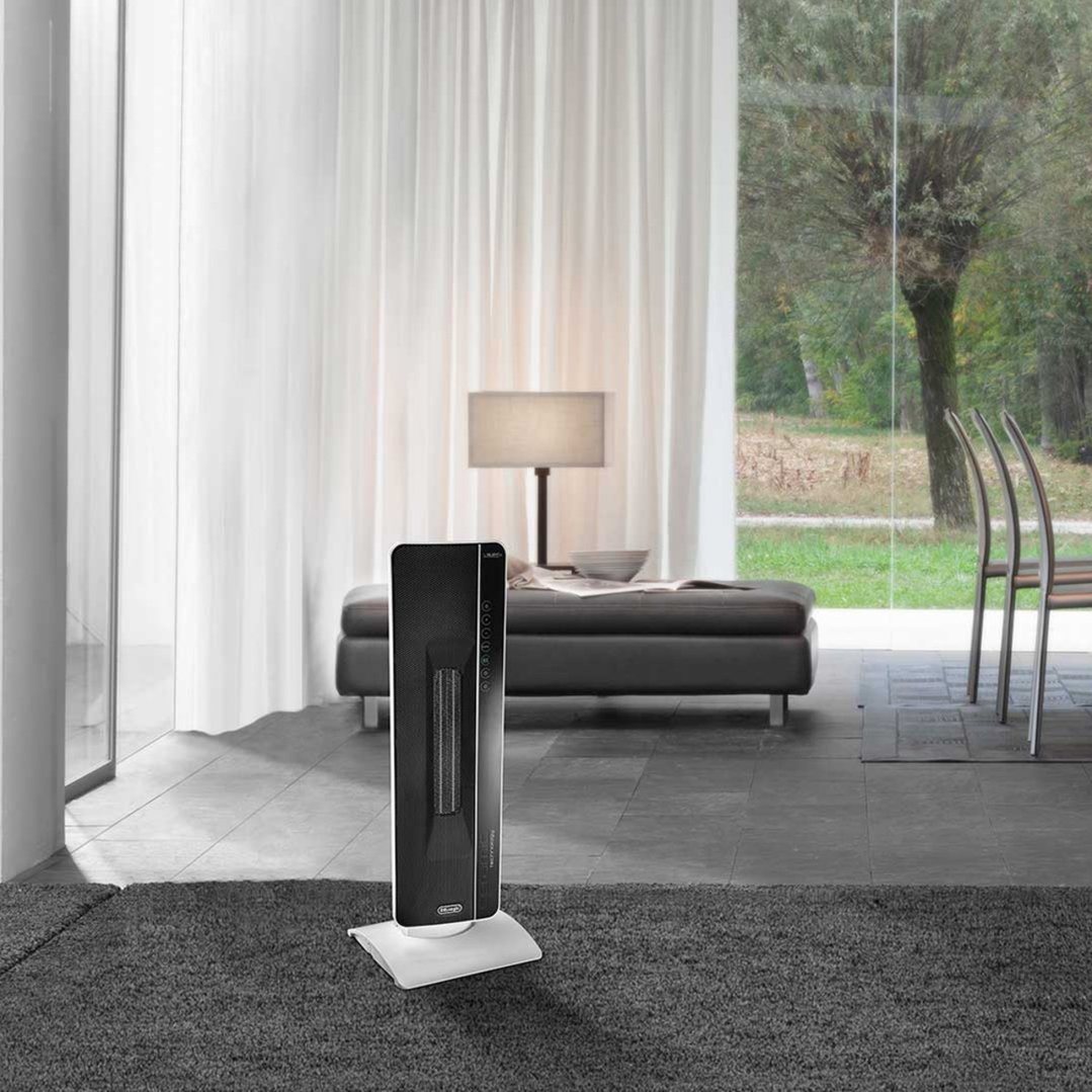 Tower ceramic heater on a stand in a modern living room with large windows