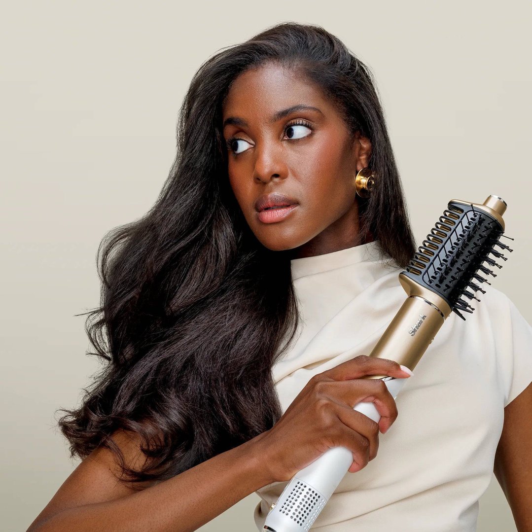 Woman holding a gold and white hot tool air drying and styling system