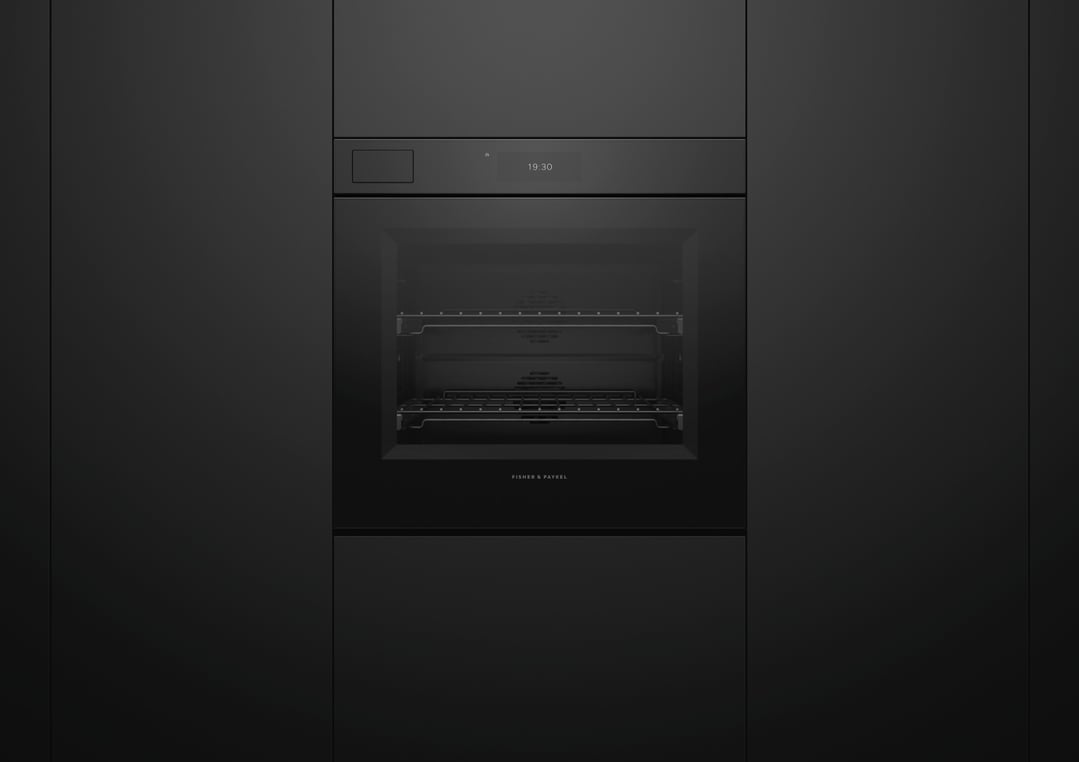 Black glass oven built into dark cabinetry with digital display showing 19:30