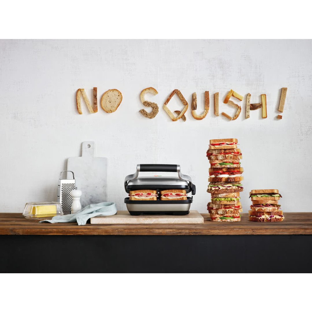 BREVILLE sandwich maker on a wooden counter with sandwiches and kitchen props