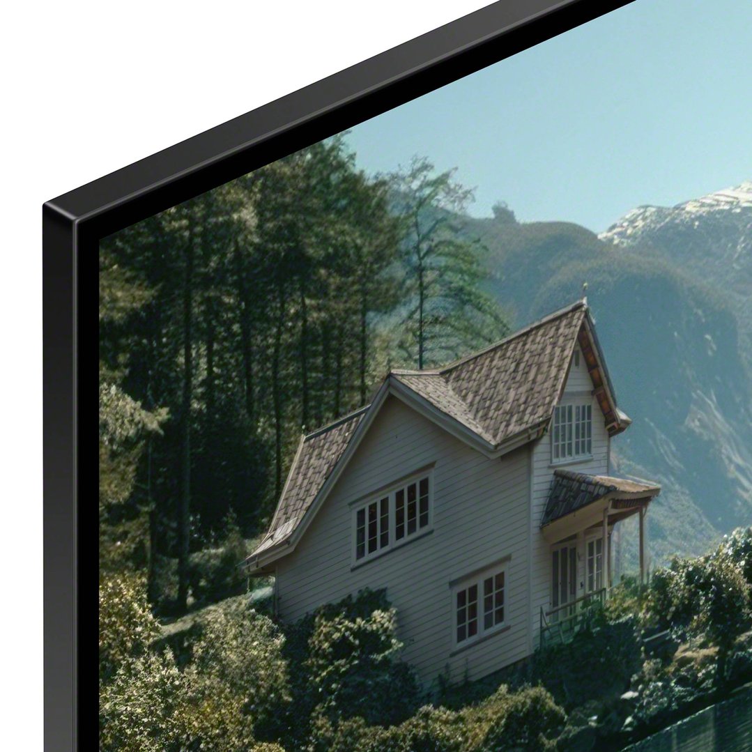 TV displaying a house on a hill with mountains and trees in the background