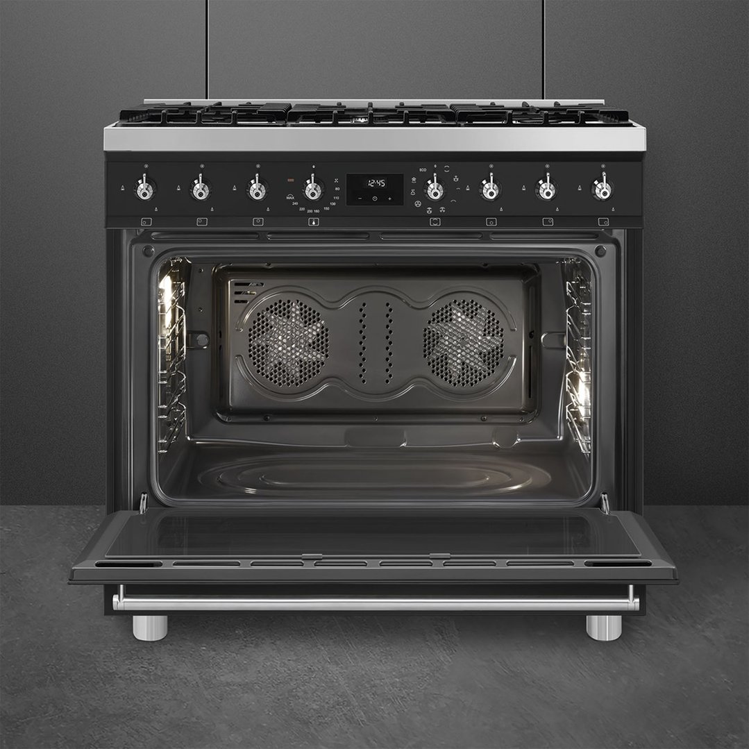 Freestanding oven with door open, showing interior and controls, in a dark kitchen