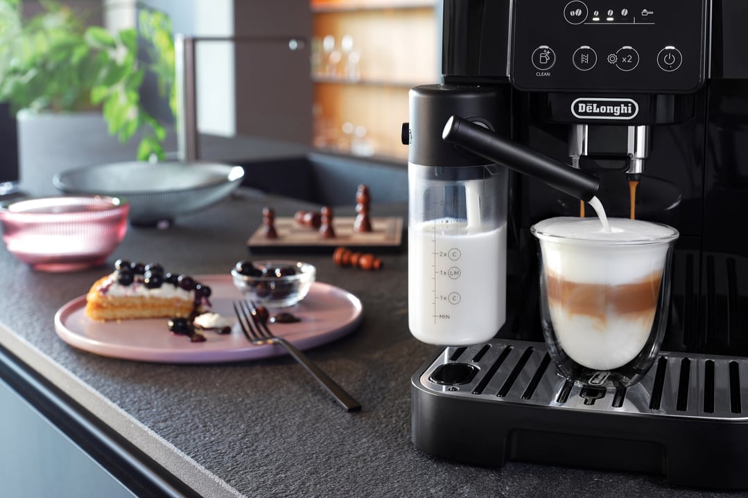 DELONGHI Magnifica Start coffee machine making a latte in a kitchen setting