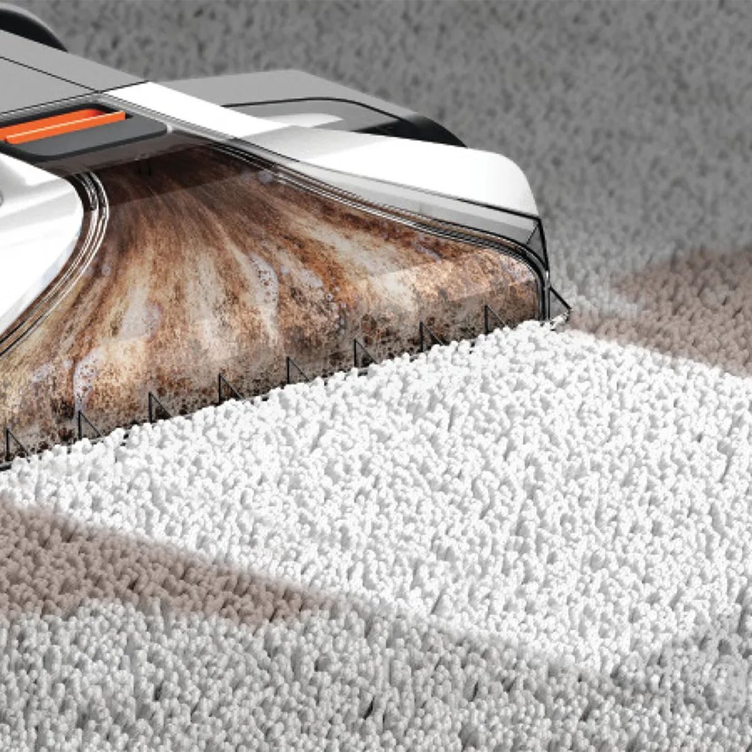 Carpet cleaner head extracting dirty water from a white carpet