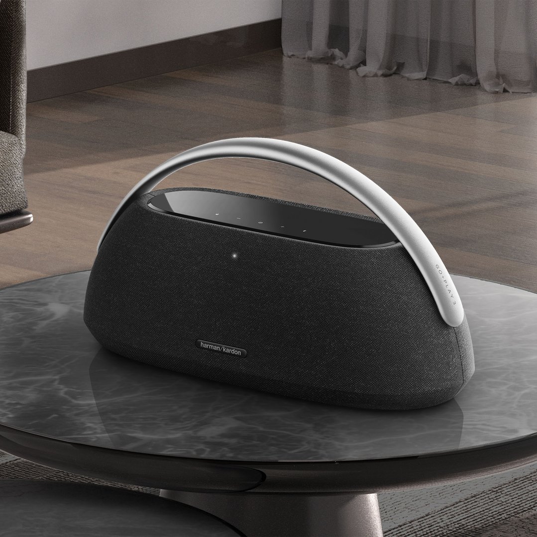 Harman Kardon Go Play 3 portable speaker on a marble-top coffee table