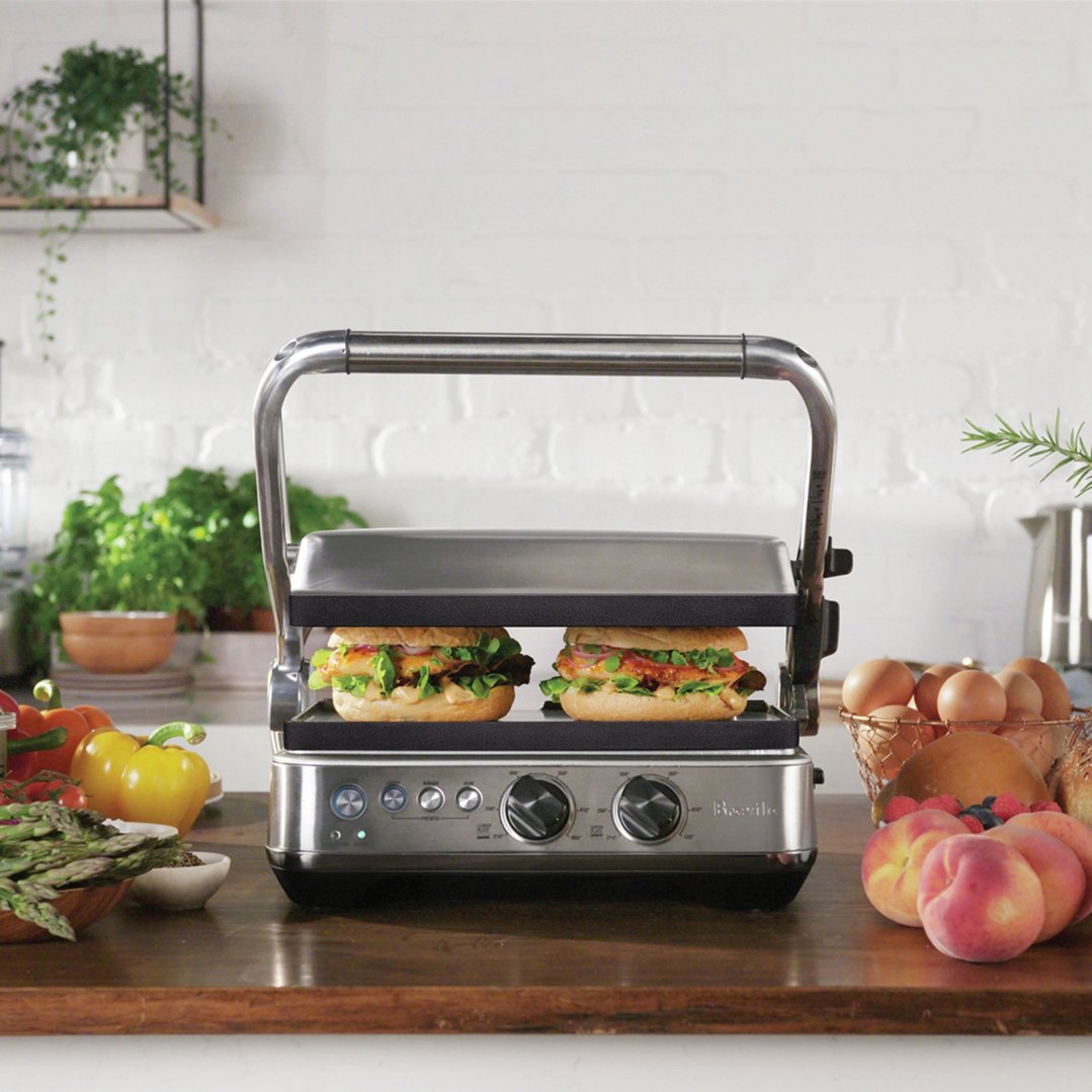 Breville Sear & Press Grill with two sandwiches on a wooden kitchen counter