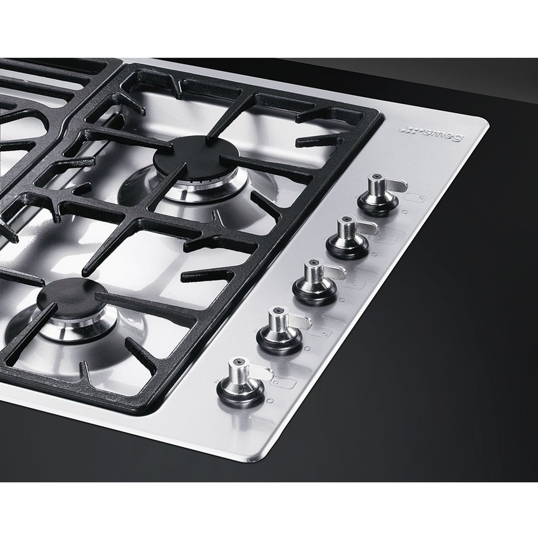 Close up of a Smeg gas cooktop with five burners and control knobs