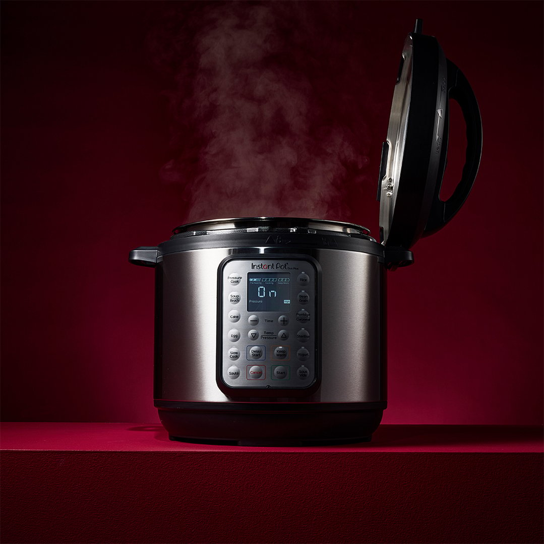 Instant Pot Duo Plus 8L multi-pressure cooker with lid open and steam rising