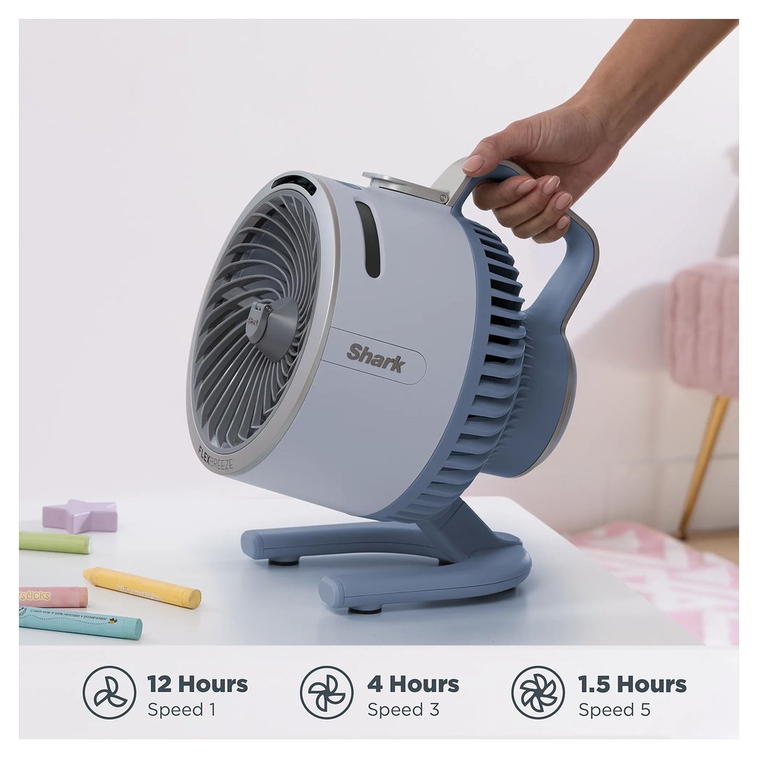 Hand holding a Shark FlexBreeze HydroGo Misting Portable Fan on a white table